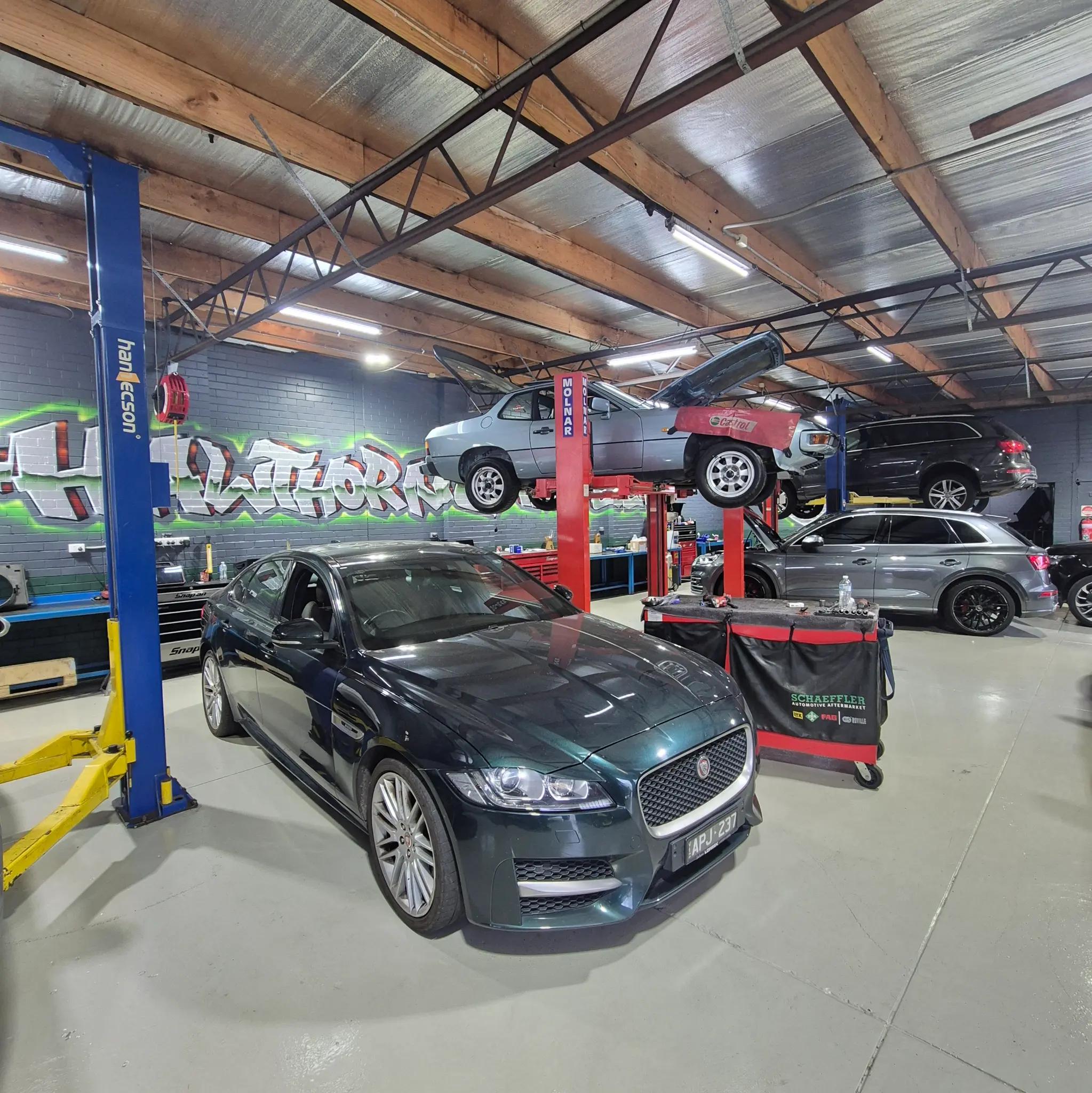 Jaguar XF and Audi Q5 in Hawthorn Eurotech workshop with car on lift