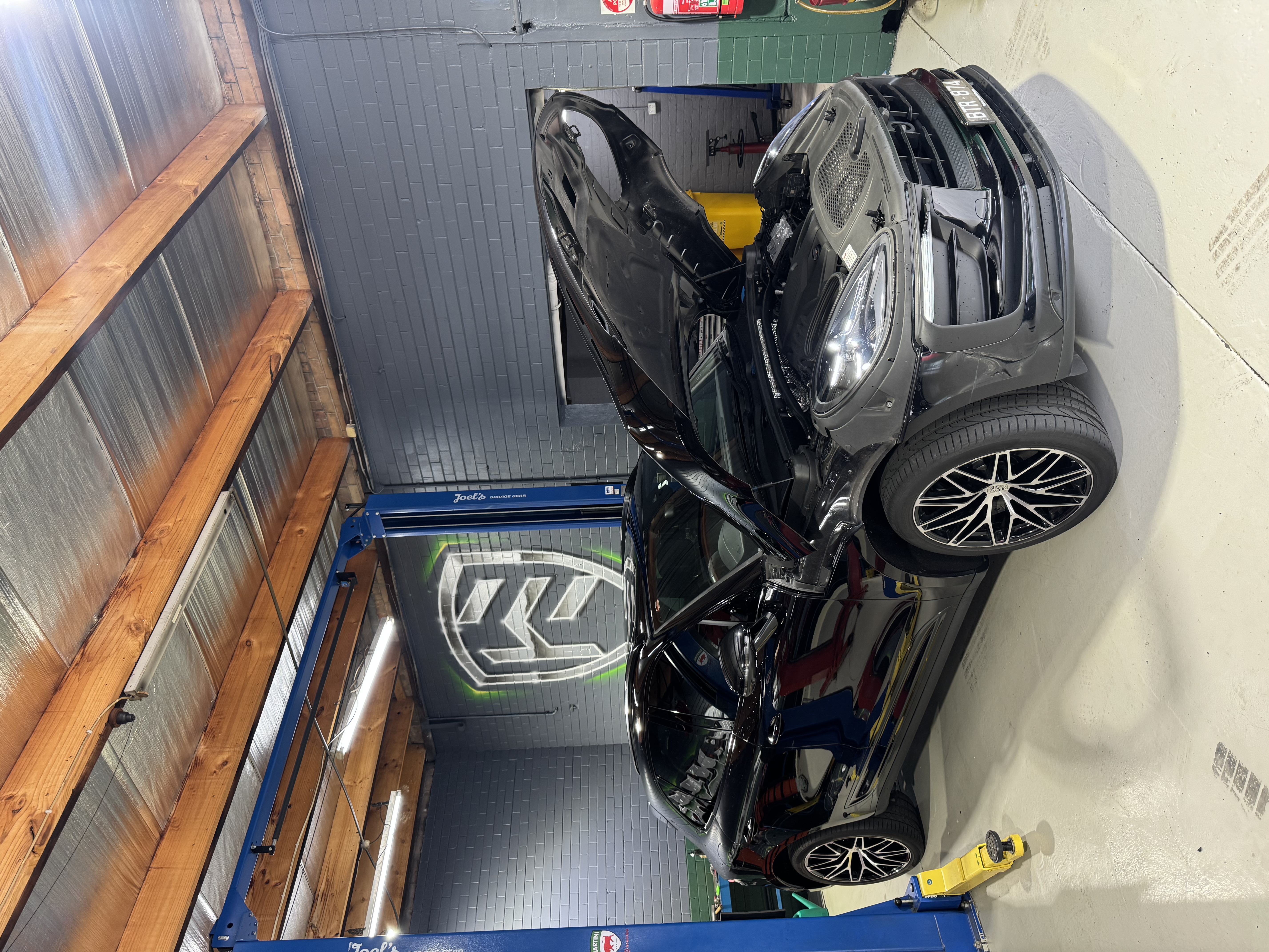 Black Porsche Macan with hood open in Hawthorn Eurotech workshop