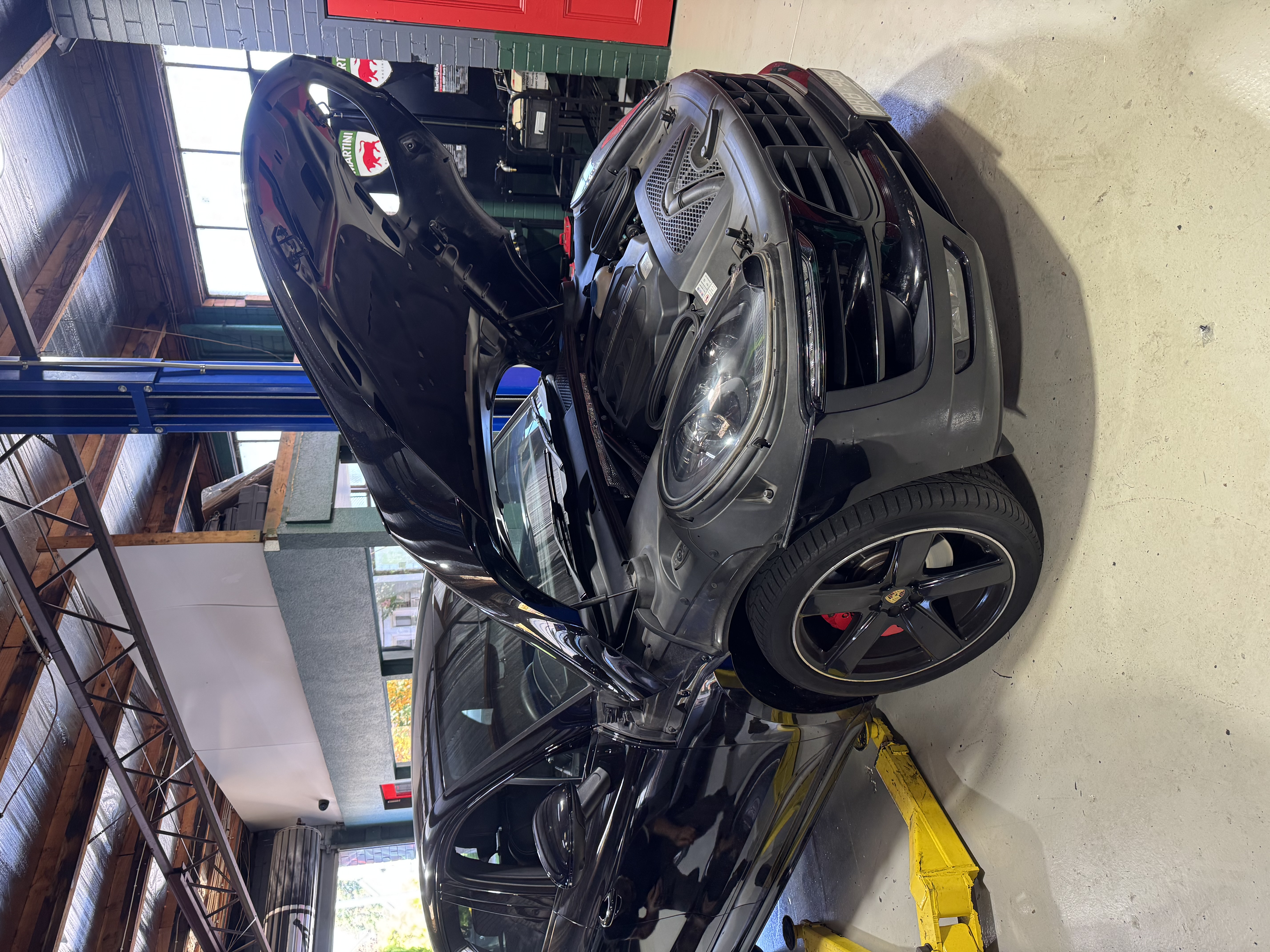 Black Porsche Macan Turbo with hood open on low lift